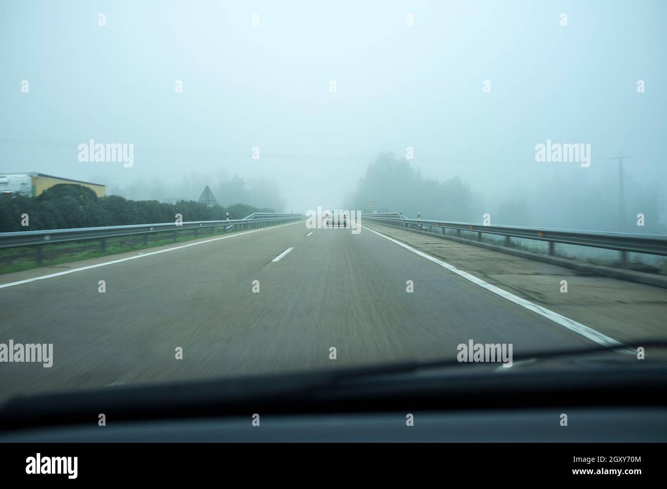 Crossing Guadiana river bridge under dense fog. Bad-weather driving concept Stock Photo