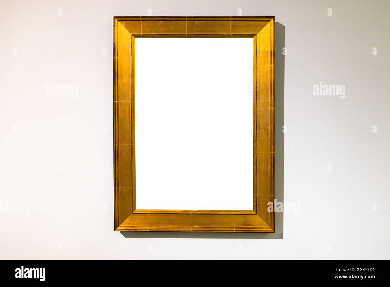 vertical wide flat golden picture frame with cutout canvas on horizontal wall Stock Photo