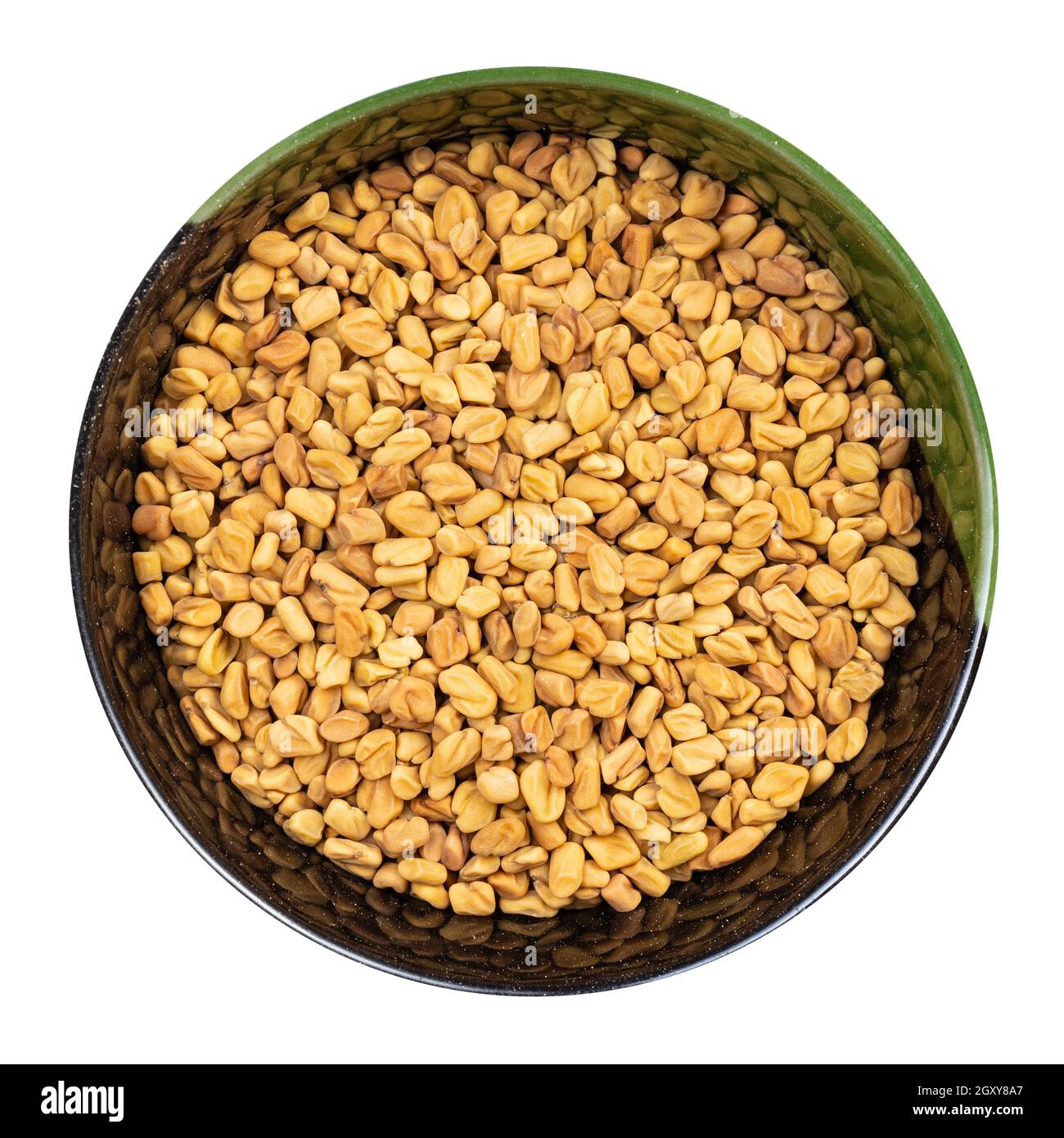 top view of whole fenugreek seeds in round bowl isolated on white background Stock Photo