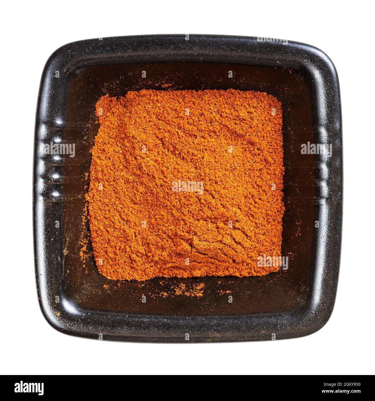 top view of chili powder from cayenne pepper in black bowl isolated on