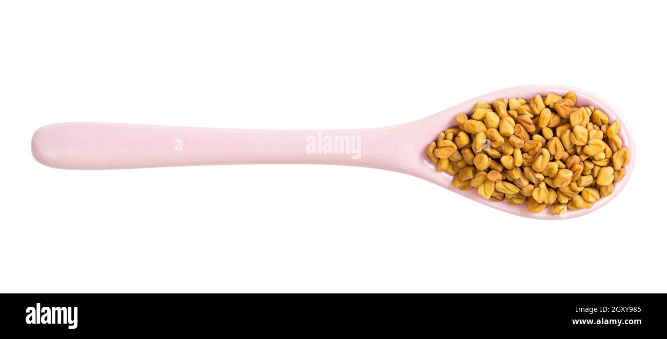 top view of ceramic spoon with fenugreek seeds isolated on white background Stock Photo