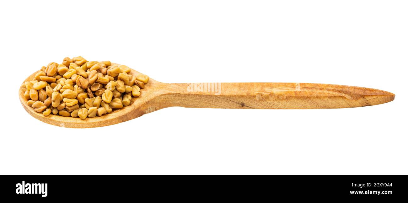 wooden spoon with fenugreek seeds isolated on white background Stock Photo