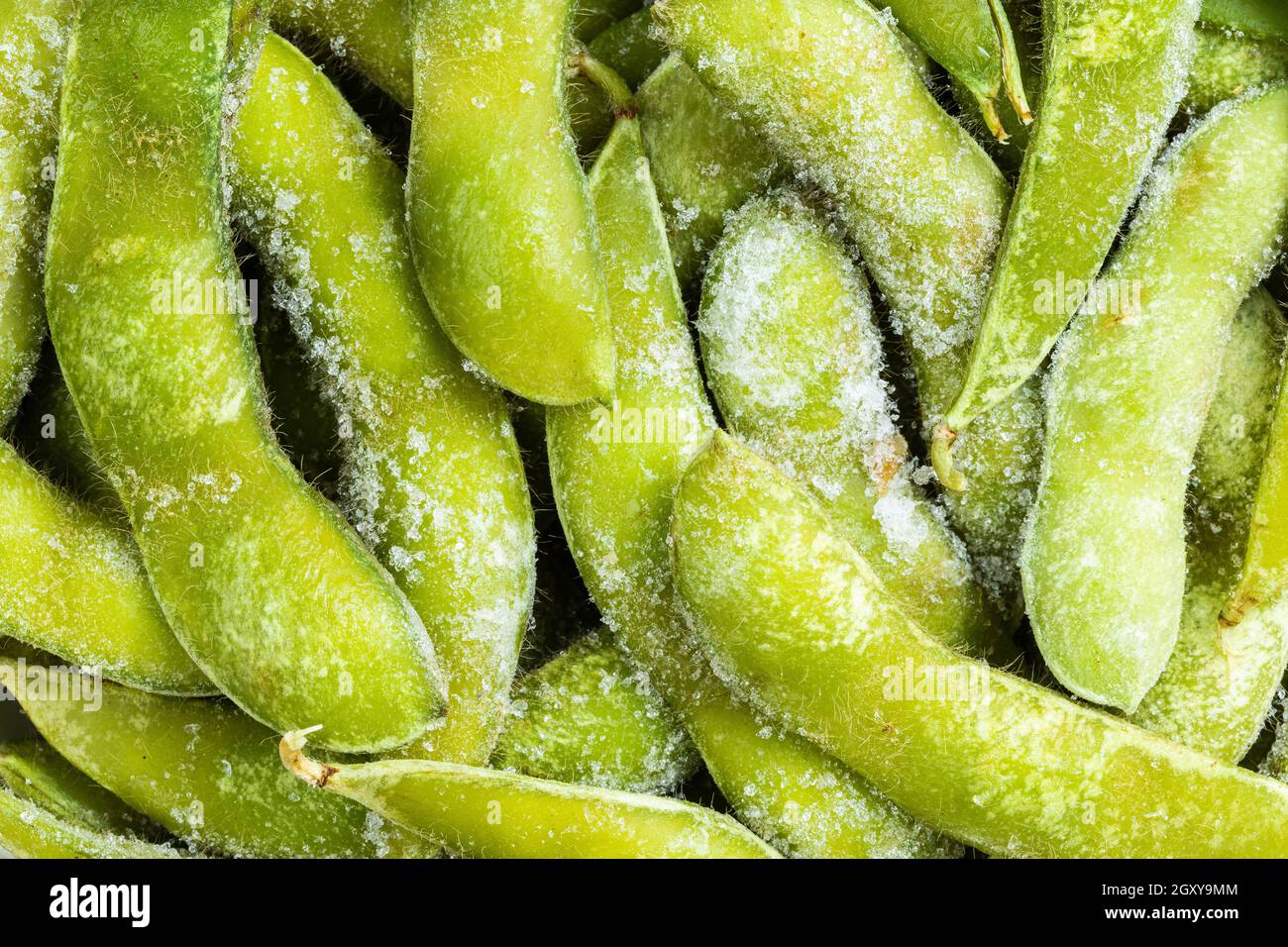 food background many frozen Edamame (unripe soybeans) pods close up