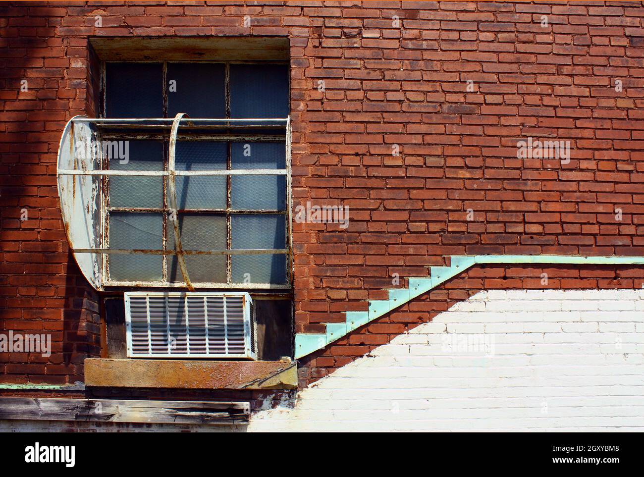 Window on a red brick wall with teal accent Stock Photo - Alamy