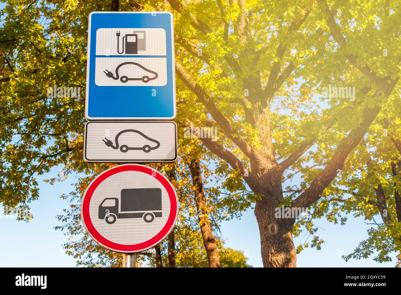 Parking for electric cars being charged. Recharging Point for Electric Vehicles Sign against nature background. Stock Photo