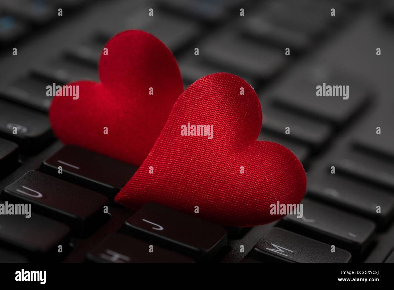 Small red hearts on computer keyboard. Internet dating concept. Stock Photo