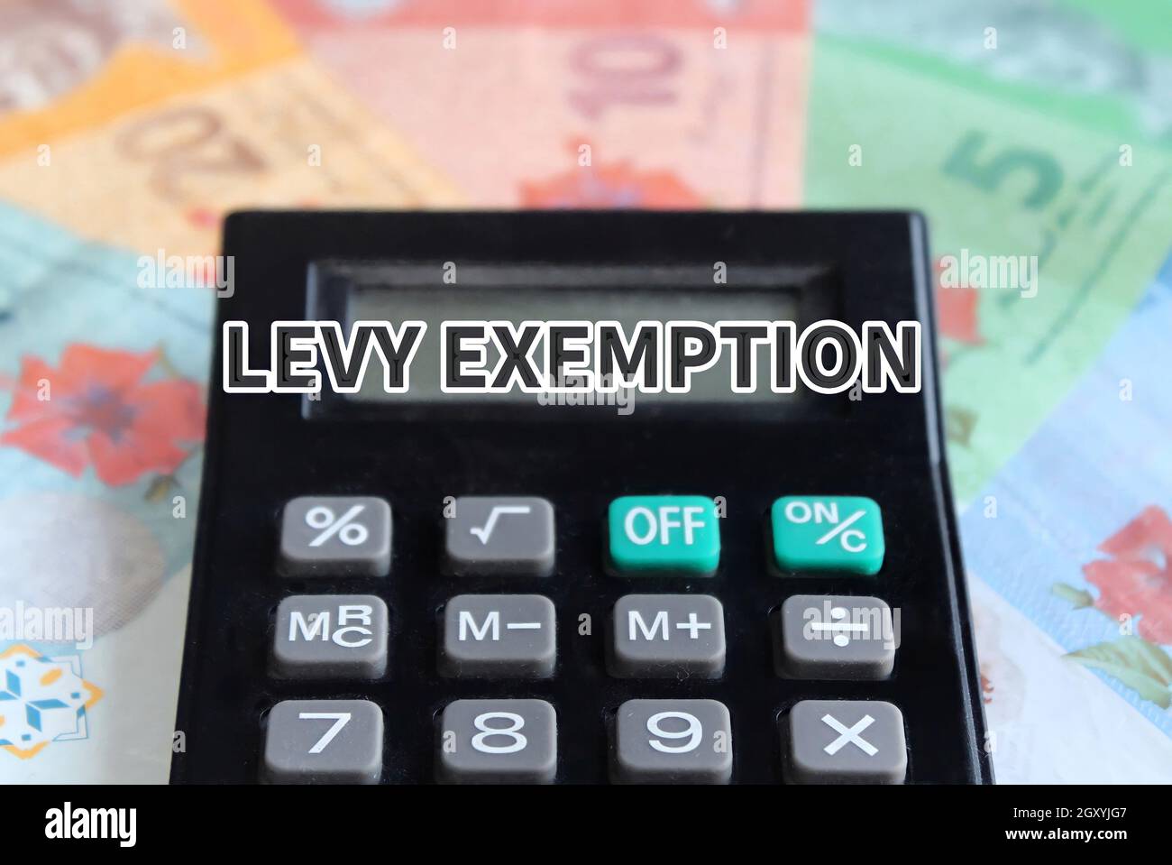 Selective focus image of calculator and Malaysian banknotes with text LEVY EXEMPTION Stock Photo