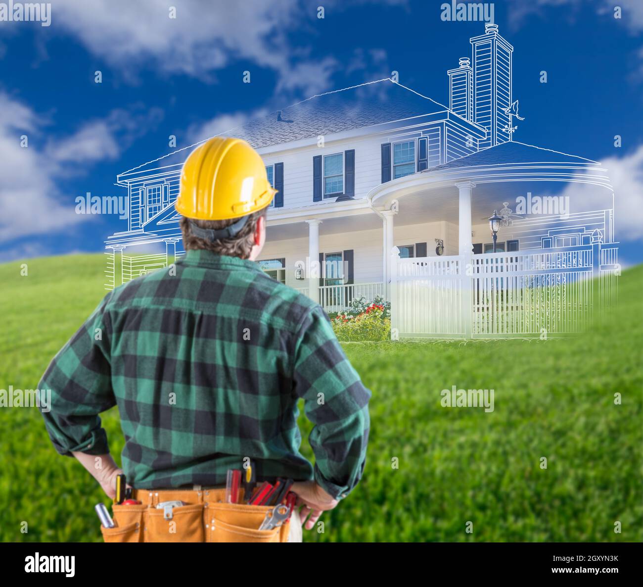 Contractor Standing Outdoors Looking Over Grass Site with Ghosted House. Stock Photo