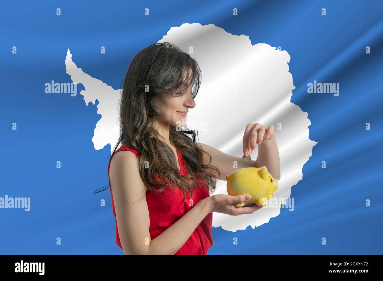 Economy in Antarctica. Accumulating and saving money in Antarctica. Woman putting money coin in piggy bank for saving money and plan finance. Stock Photo