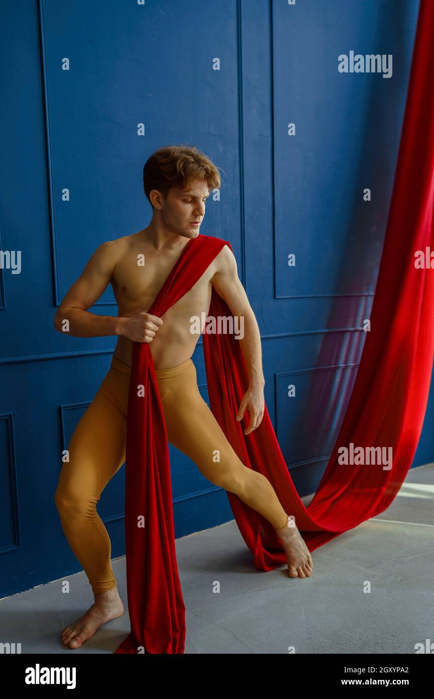 Male ballet dancer performing with red cloth in dancing studio, blue walls  on background. Performer with muscular body, grace of movements Stock Photo  - Alamy