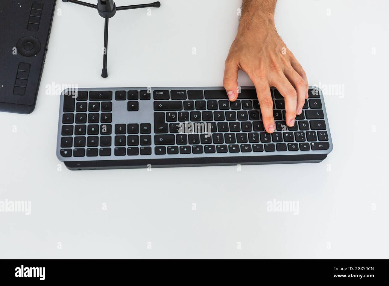 Anonymous male working on computer at table with graphic tablet Stock Photo