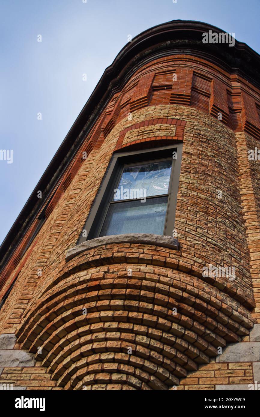 Brick building with a rounded window jutting out of a corner Stock