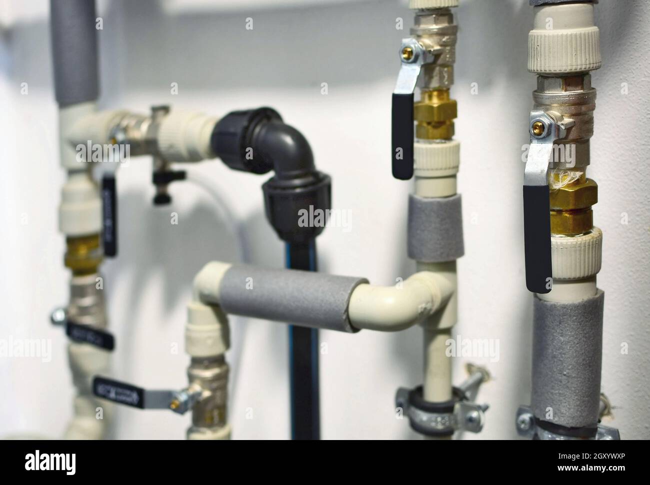 Closeup of an interior home plastic water piping with water shuts and