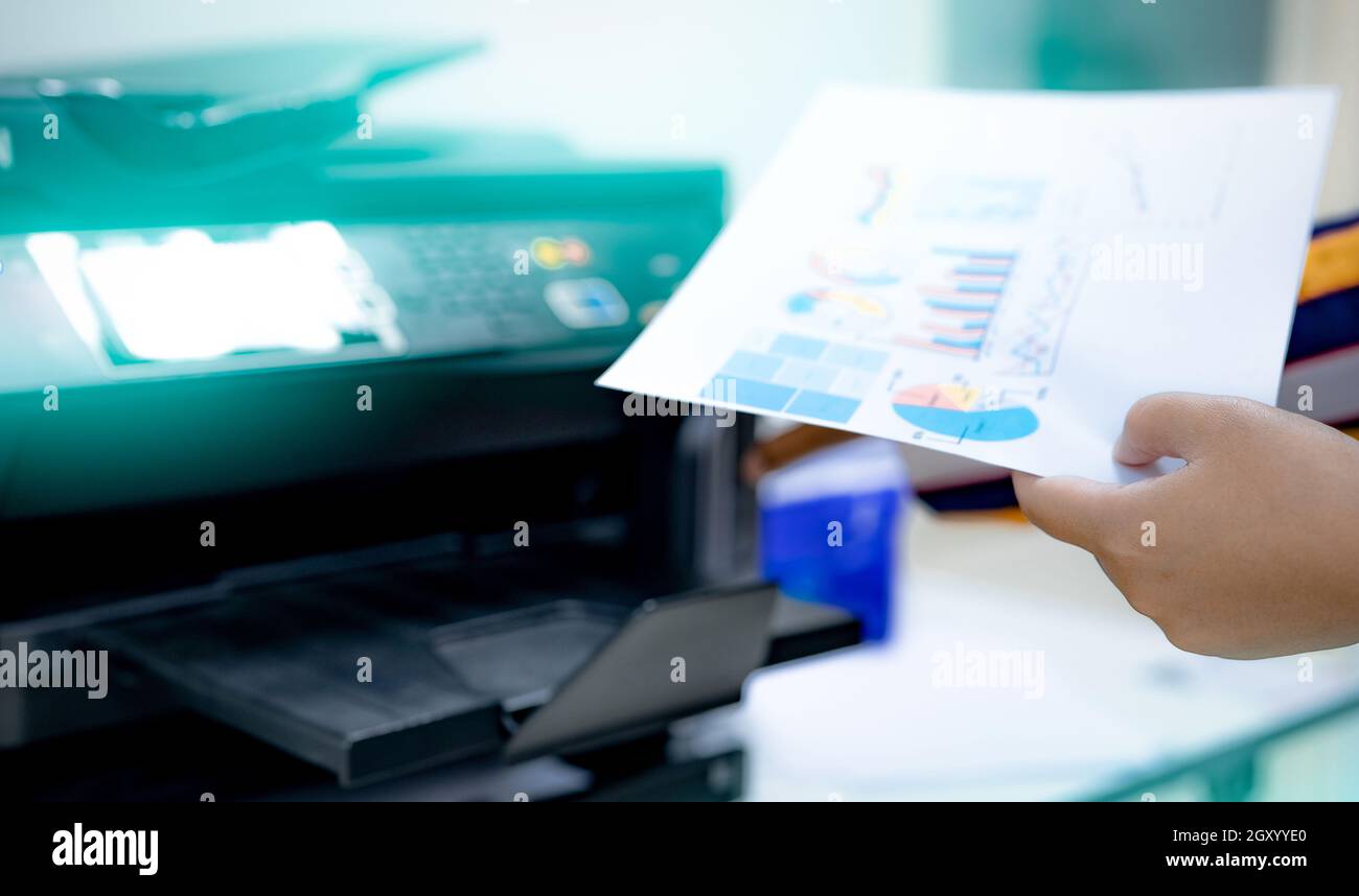 Selective focus on office worker hand holding paper. Multifunction ...