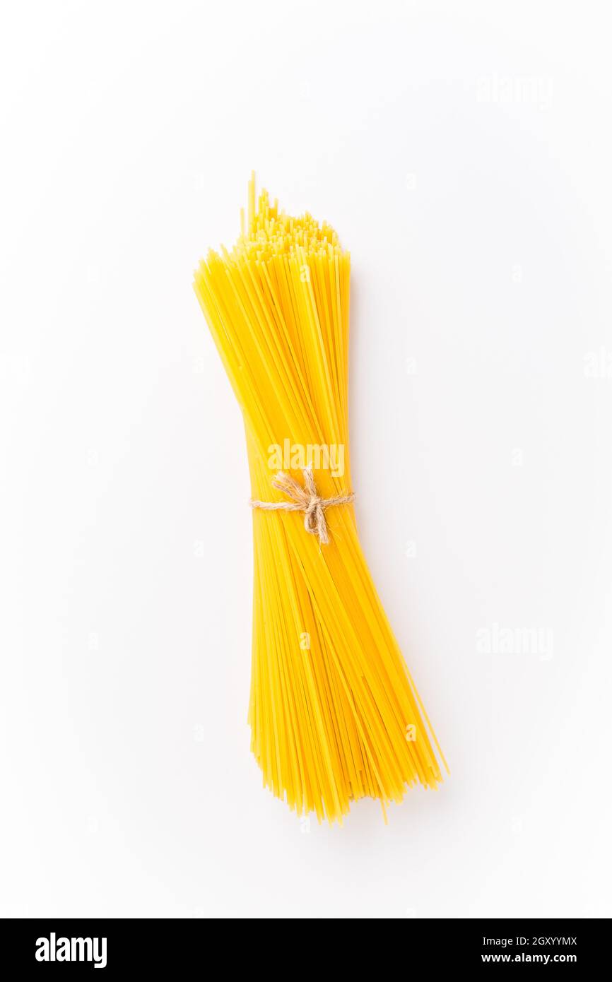 Spaghettini - thinner Spaghetti. Raw Spaghetti on white background. Stock Photo
