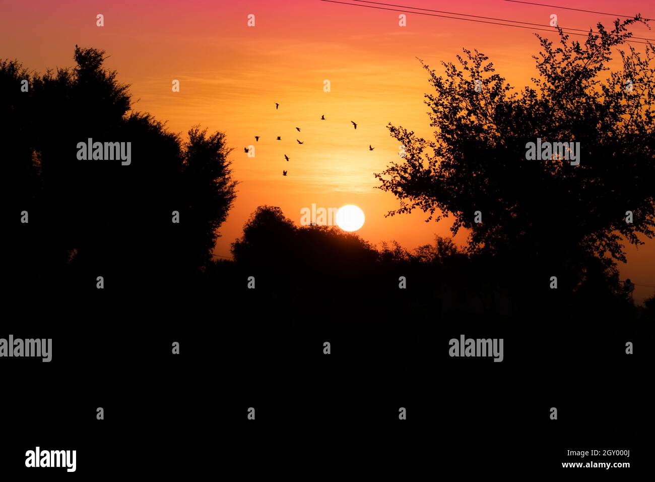 Attractive landscape photograph of sunrise in the morning view and Beautiful view of silhouette trees and silhouette hills and rising sun in the count Stock Photo