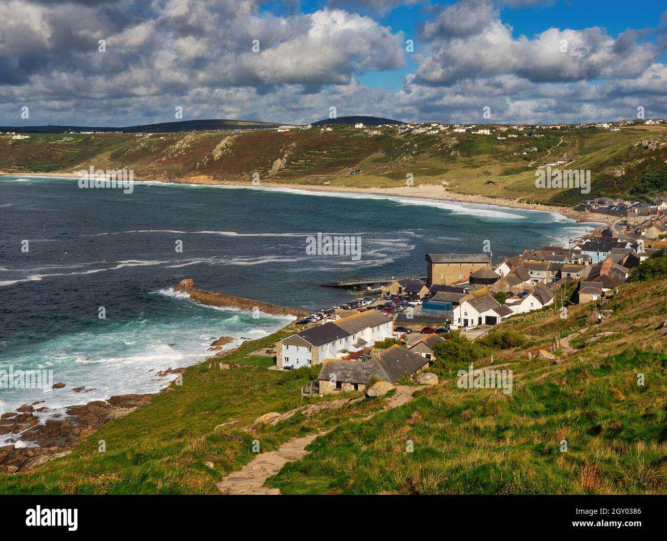 Looking from Mayon Cliff Lookout point as the South West Coastal Path drops down into Sennen Cove, curving around in the distance to Sennen Beach. Stock Photo