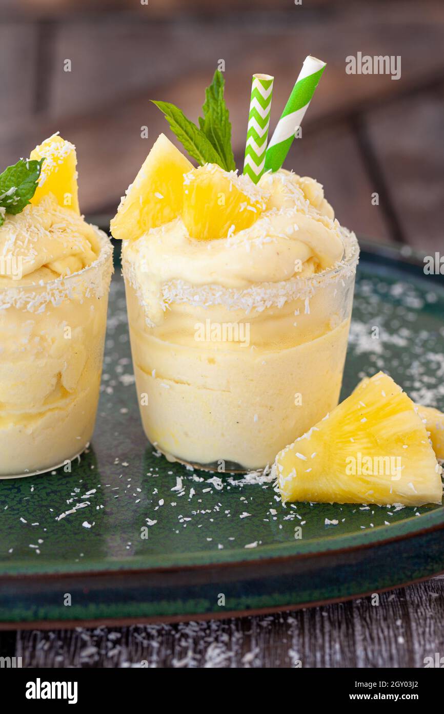 Delicious pineapple soft serve with coconut flakes and mint leaves Stock Photo