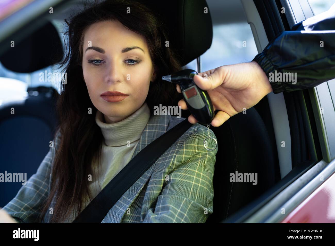 Verification alcoolemie. Ethylotest. Girl driver does alcohol test in the  car, safe driving concept, drugs, drunk driving, negative positive result,  police check, he Stock Photo