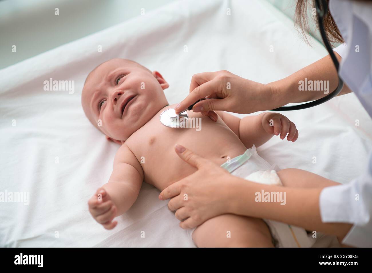 Cute baby undergoing the heart auscultation procedure Stock Photo