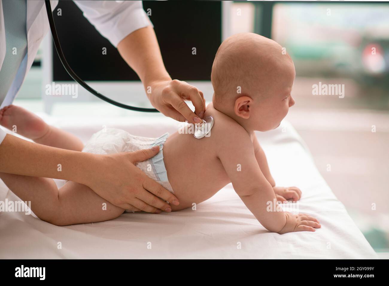 Newborn Caucasian patient being examined with a sterile stethoscope Stock Photo