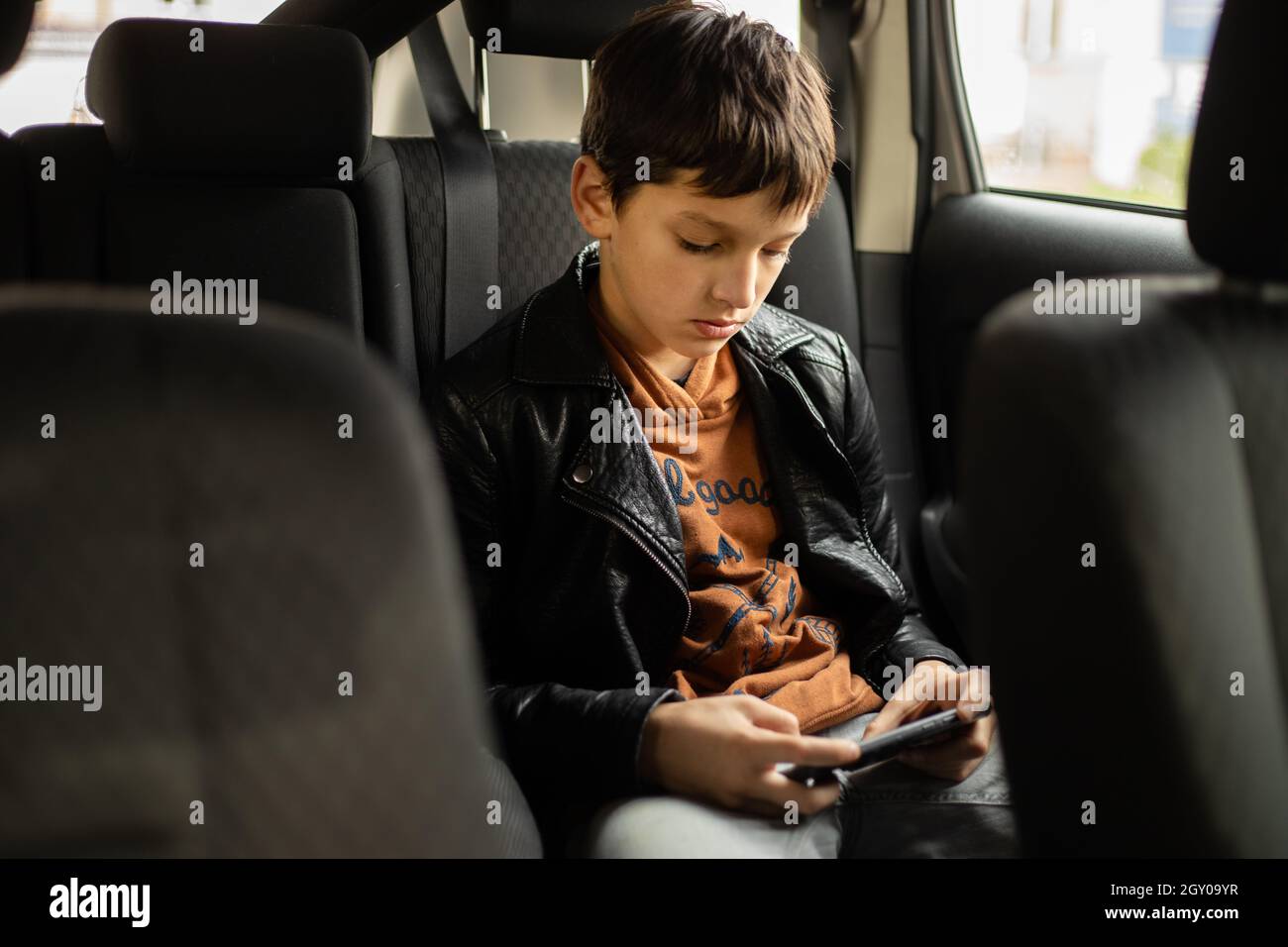 Passenger Teenage Boy in car using smart phone on Back Seat, Vertical photo Stock Photo Alamy