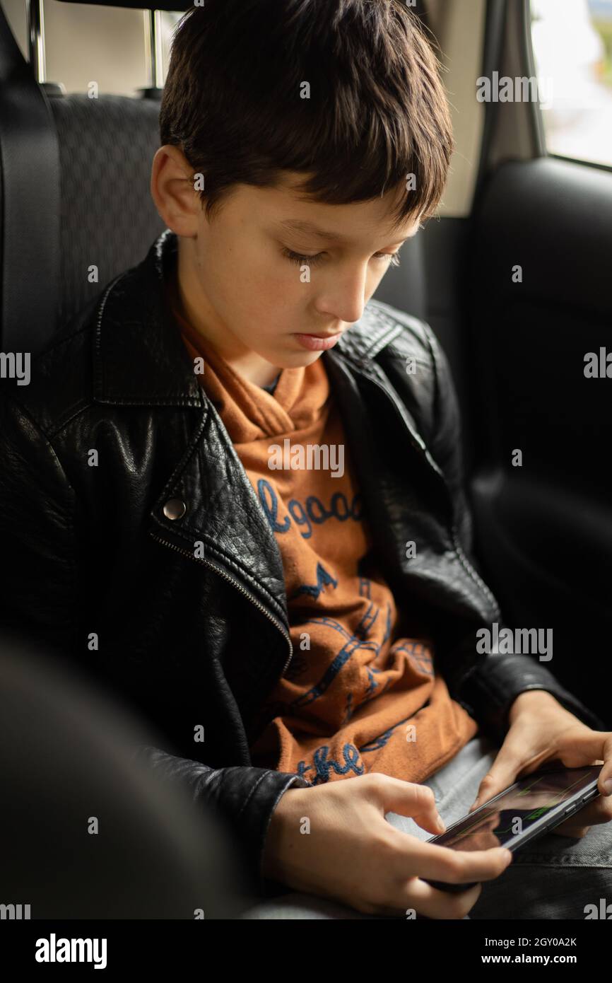 Passenger Teenage Boy in car using smart phone on Back Seat, Horizontal photo Stock Photo Alamy