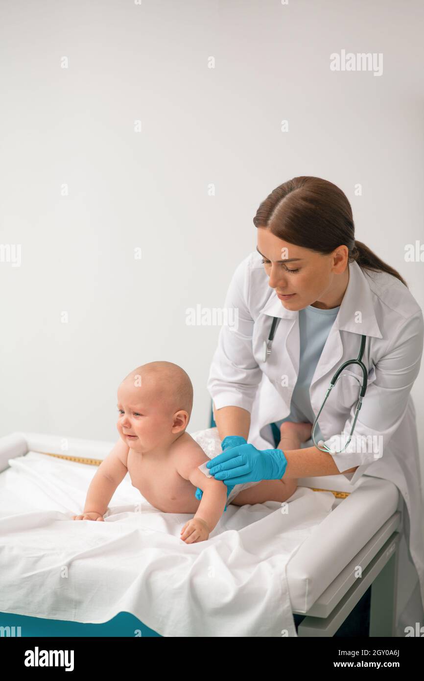 Experienced healthcare professional preparing a child for a shot Stock Photo