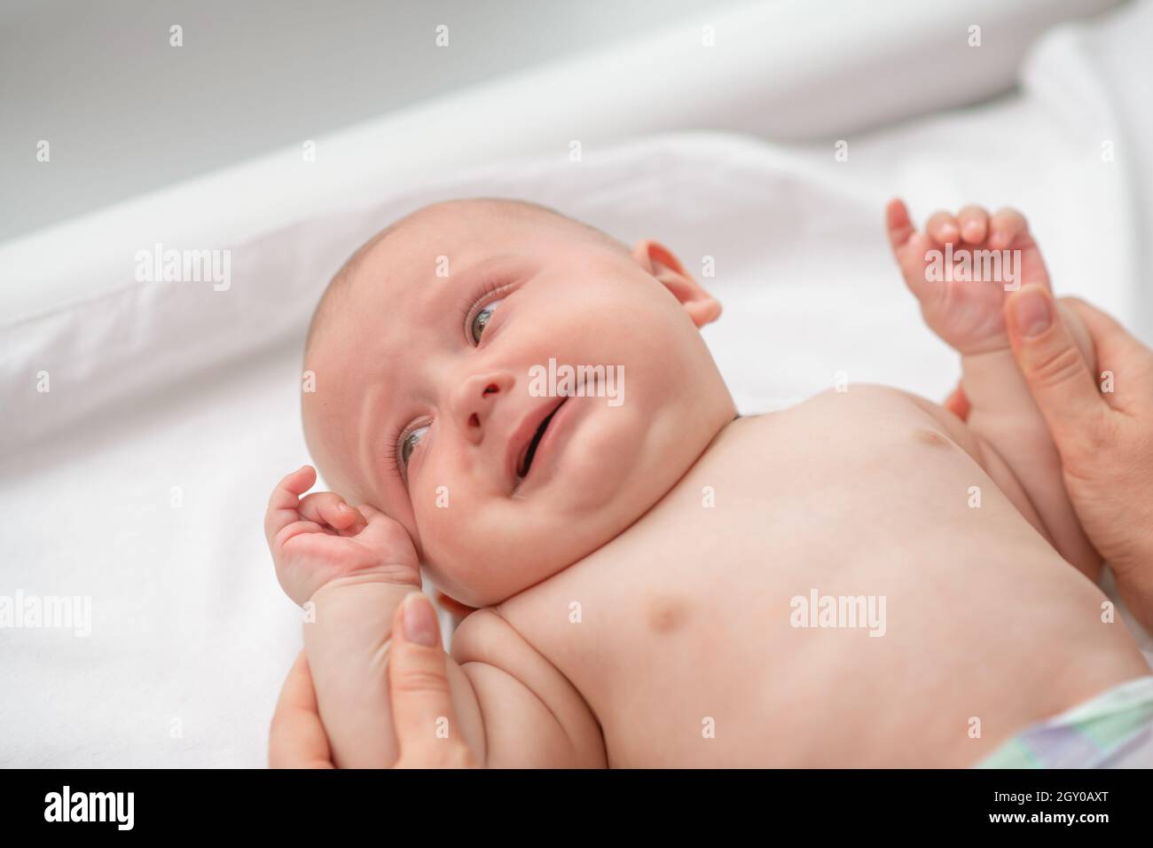 Calm newborn baby being examined by a certified healthcare professional Stock Photo