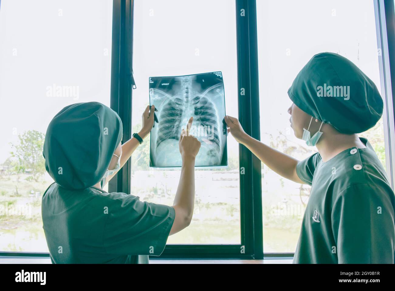 Doctor checking examining chest x-ray film of patient at ward hospital. Stock Photo