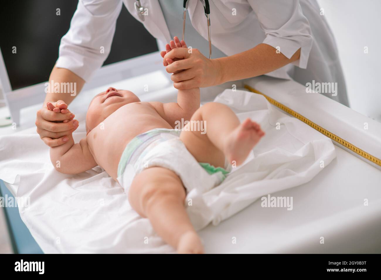 Experienced pediatrician checking the newborn grasp reflex Stock Photo