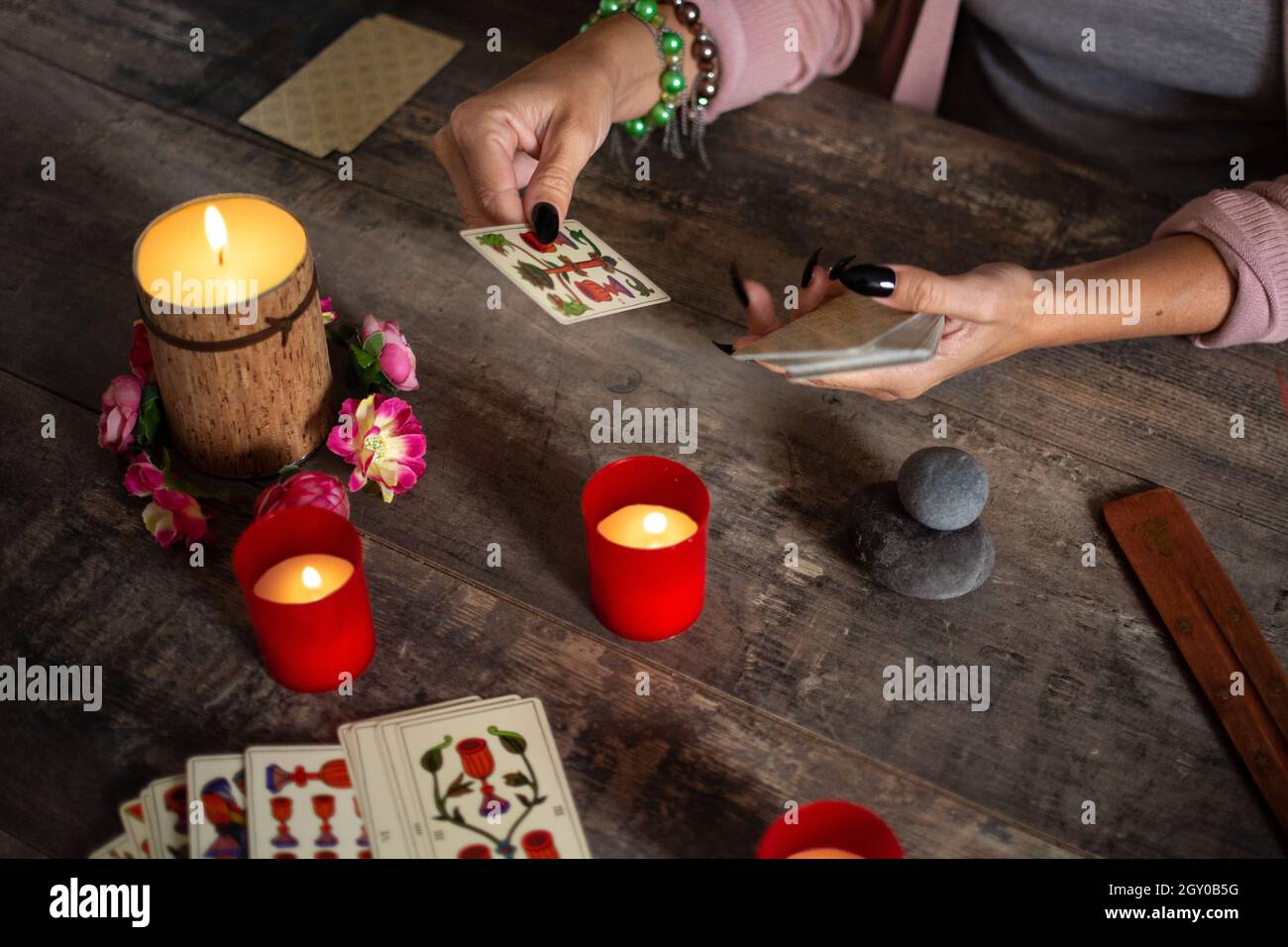Fortune teller reading a future by tarot cards on rustic table Stock Photo
