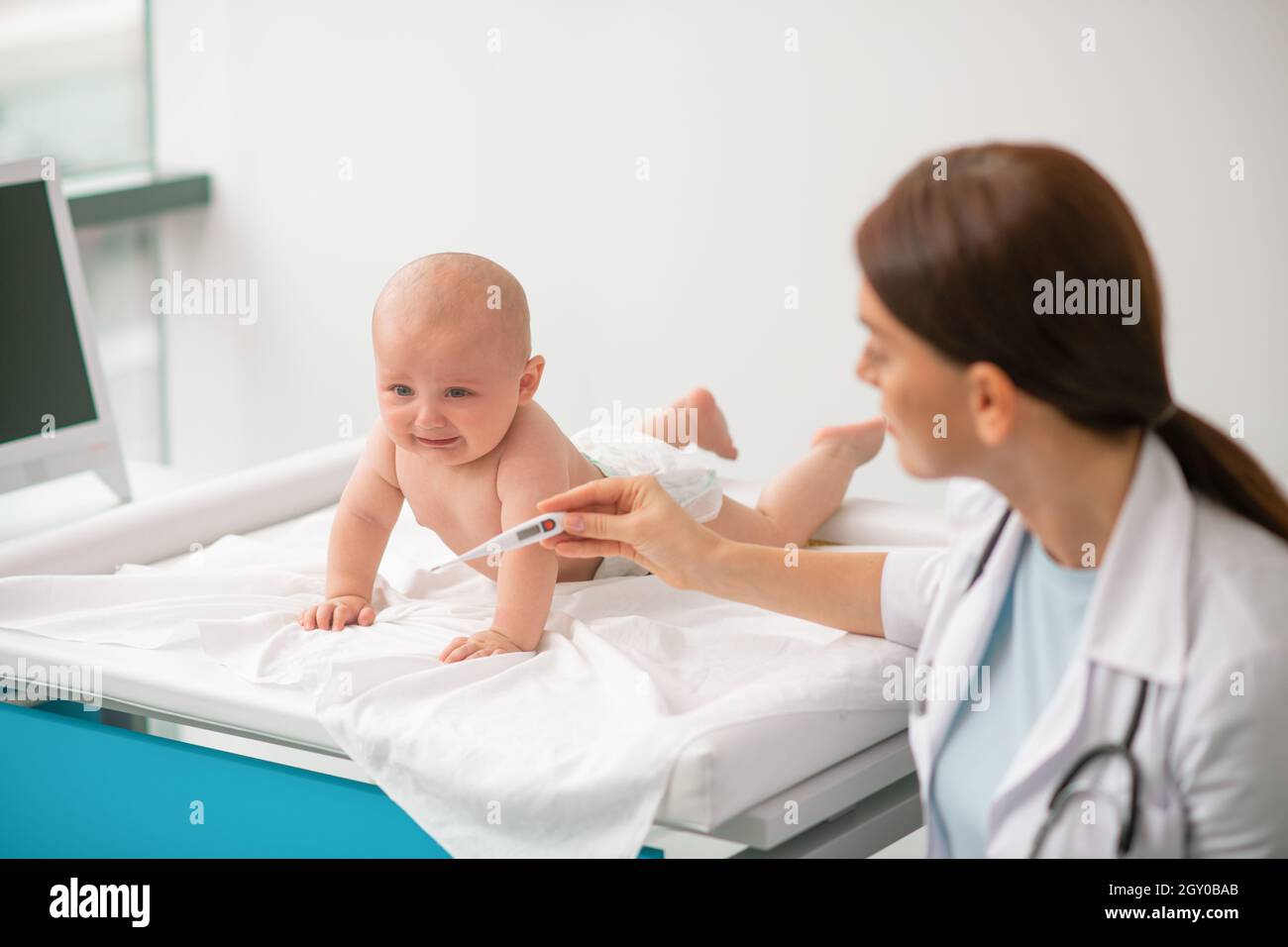 Experienced healthcare professional getting ready to take a newborn temperature Stock Photo