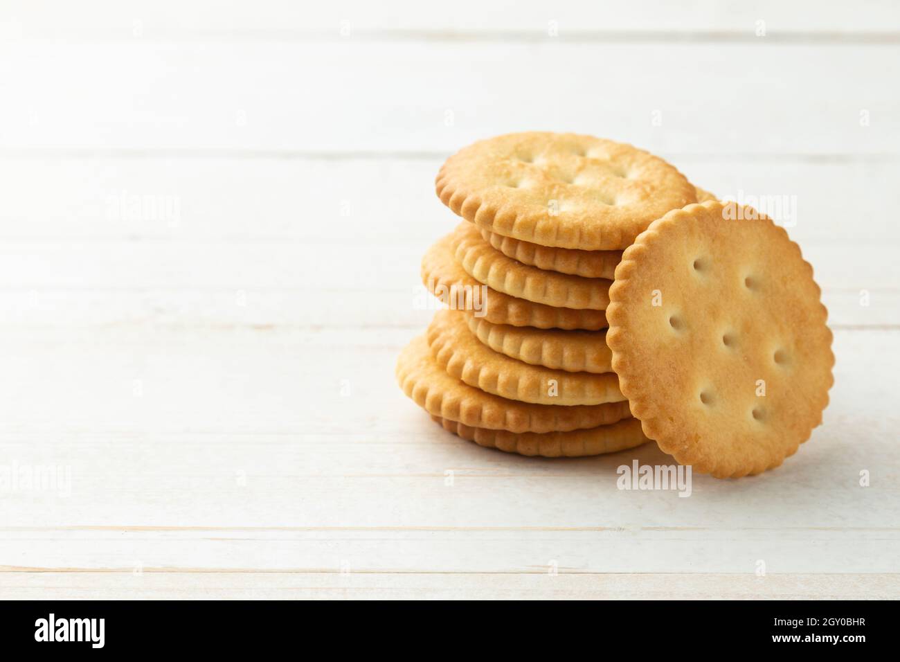 Rounded Cracker cookies on white wooden table background. Stock Photo