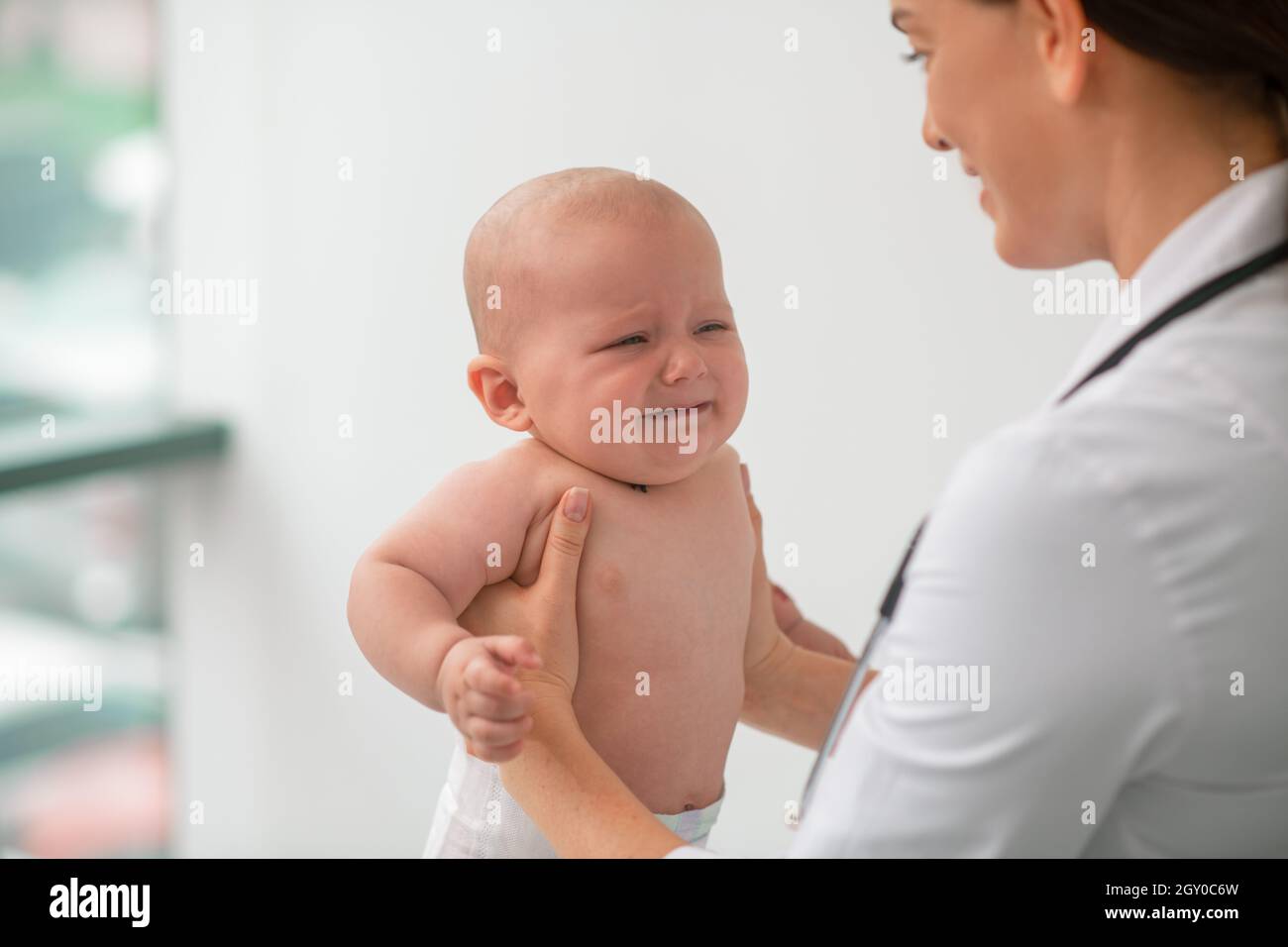 Attentive doctor examining a frightened pediatric patient Stock Photo
