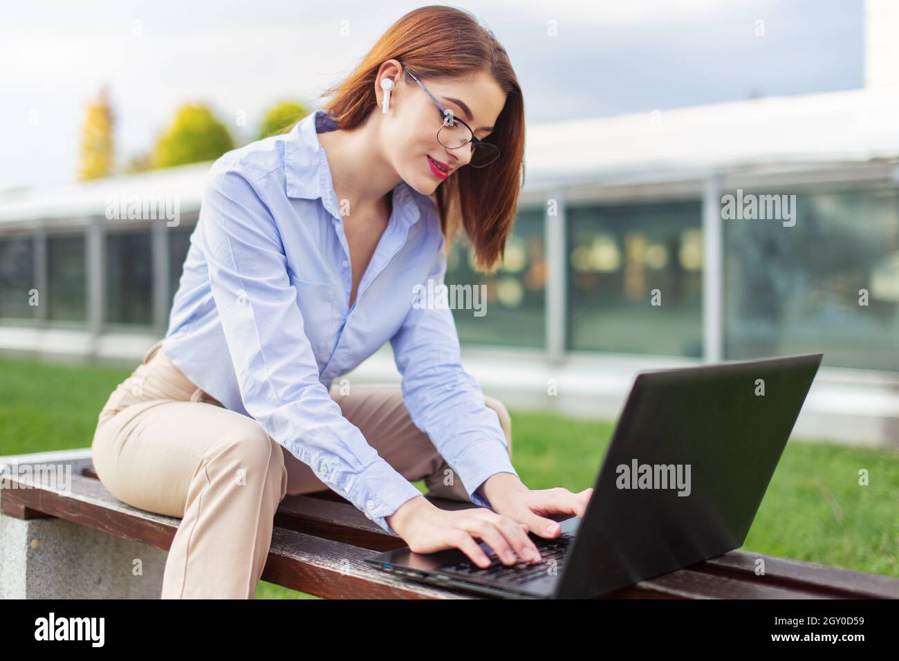 Young entrepreneur Caucasian woman using laptop in park, wireless communication Stock Photo