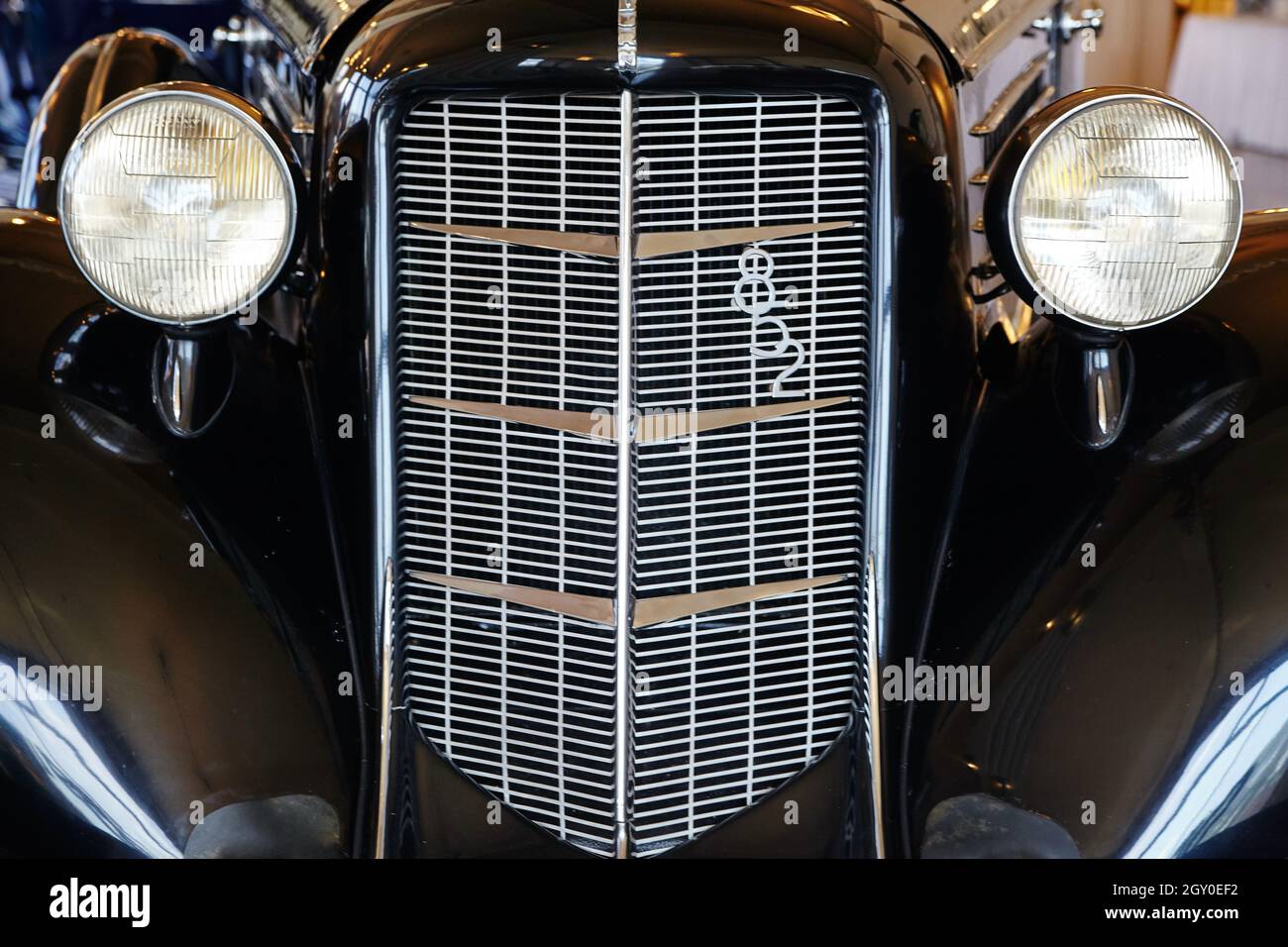 Close-up front shot of an antique car with a tall front grill and two lights like eyes Stock Photo