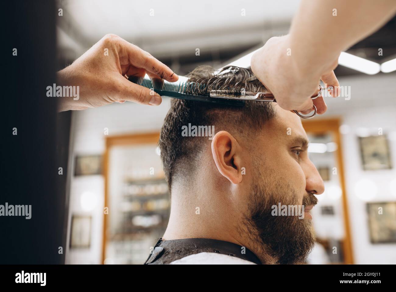 Man getting haircut at the barbershop. Professional barber at work process.  Beauty, selfcare, style, fashion, healthcare and male cosmetics concept  Stock Photo - Alamy