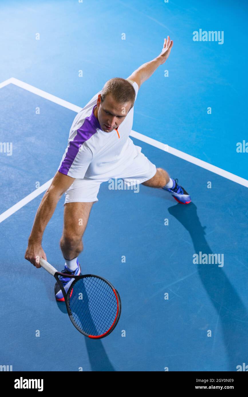 Top view portrat of professional tennis player, sportsman in uniform  training over gym background Stock Photo - Alamy