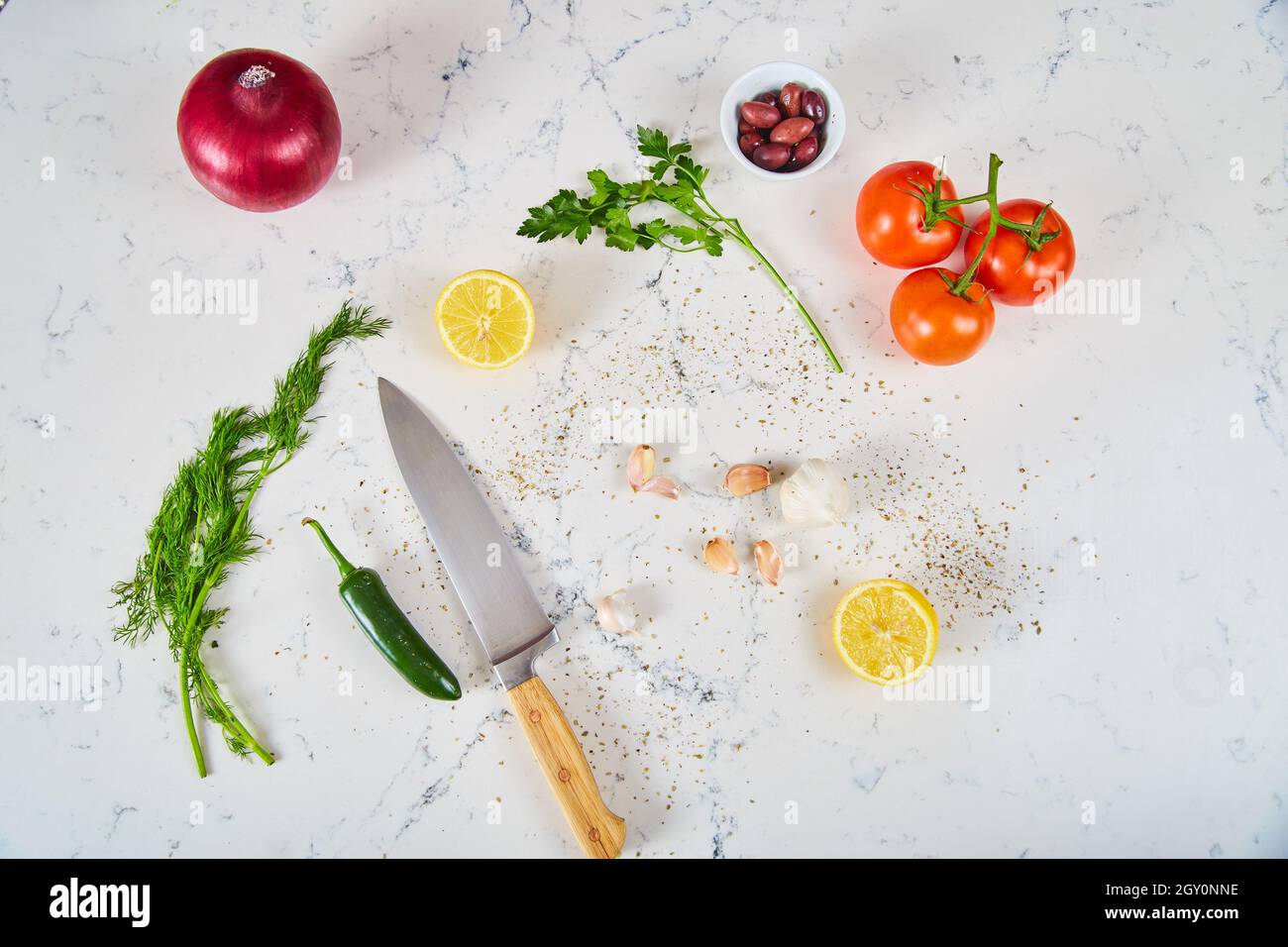 Fresh produce ingredients, spices, and knife on white marble Stock Photo