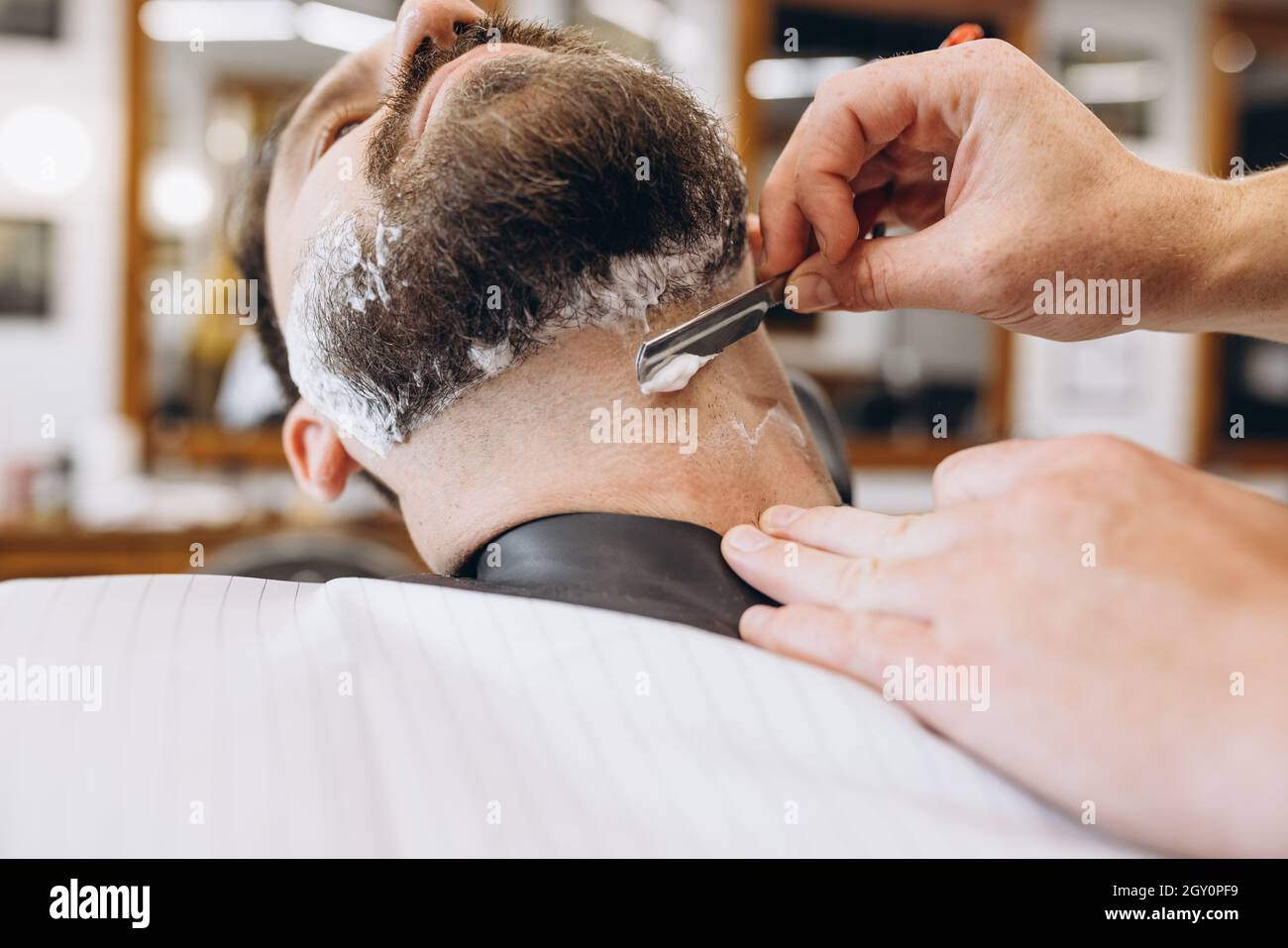 Man getting haircut at the barbershop. Professional barber at work ...