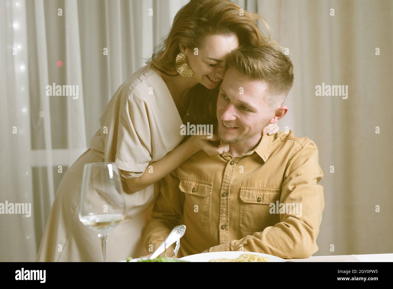 young couple at the table, the woman bent over the man. concept for