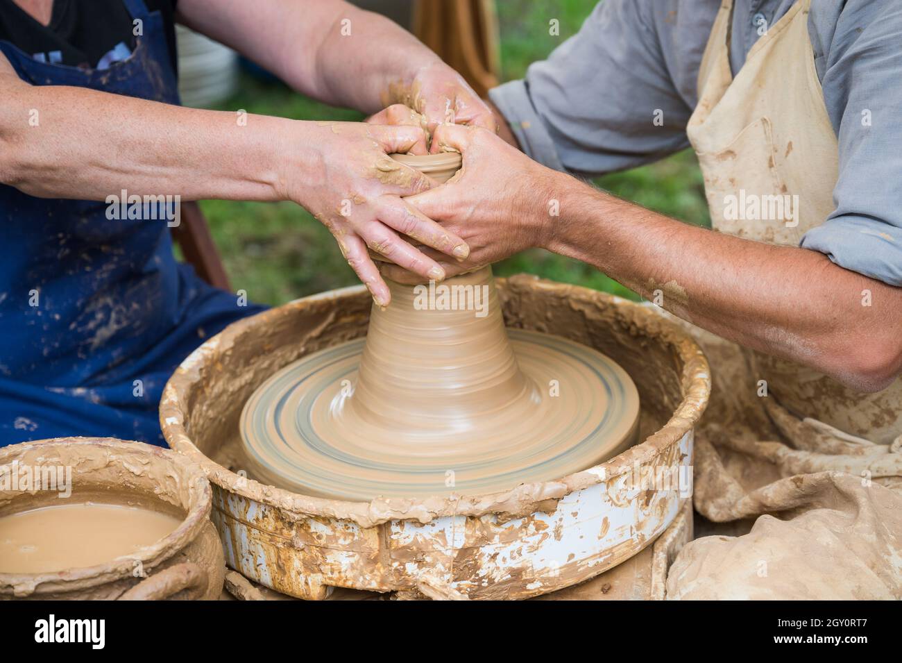Hands of a woman (student) and a man (teacher) during a pot making workshop Stock Photo