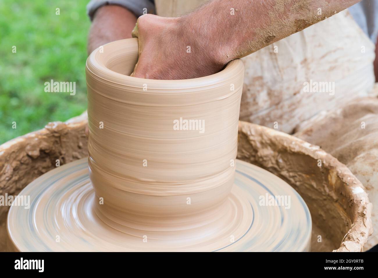 Hands of a man making a clay vase on a potter's wheel Stock Photo