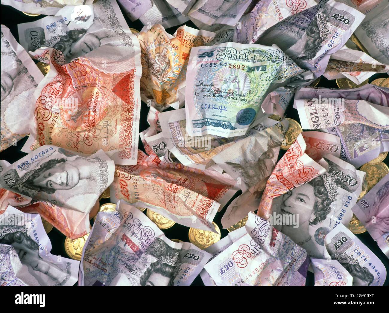 Close up background concept image screwed up historical UK trashed thrown away obsolete & redundant sterling paper banknotes in a plastic & card age Stock Photo
