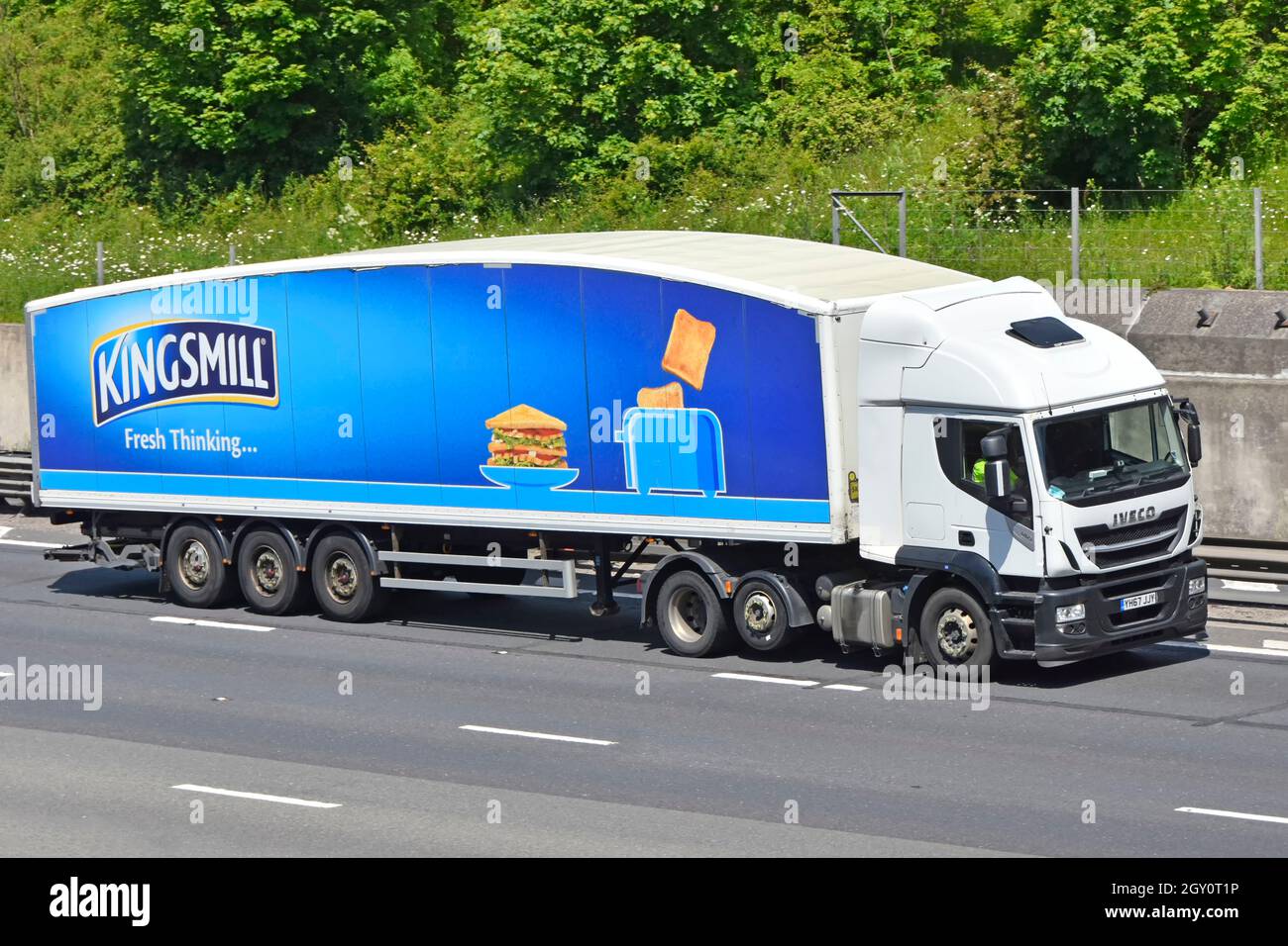 Advertising on articulated trailer for Kingsmill bread a brand owned by Associated British Foods behind an Iveco lorry truck driving on UK motorway Stock Photo