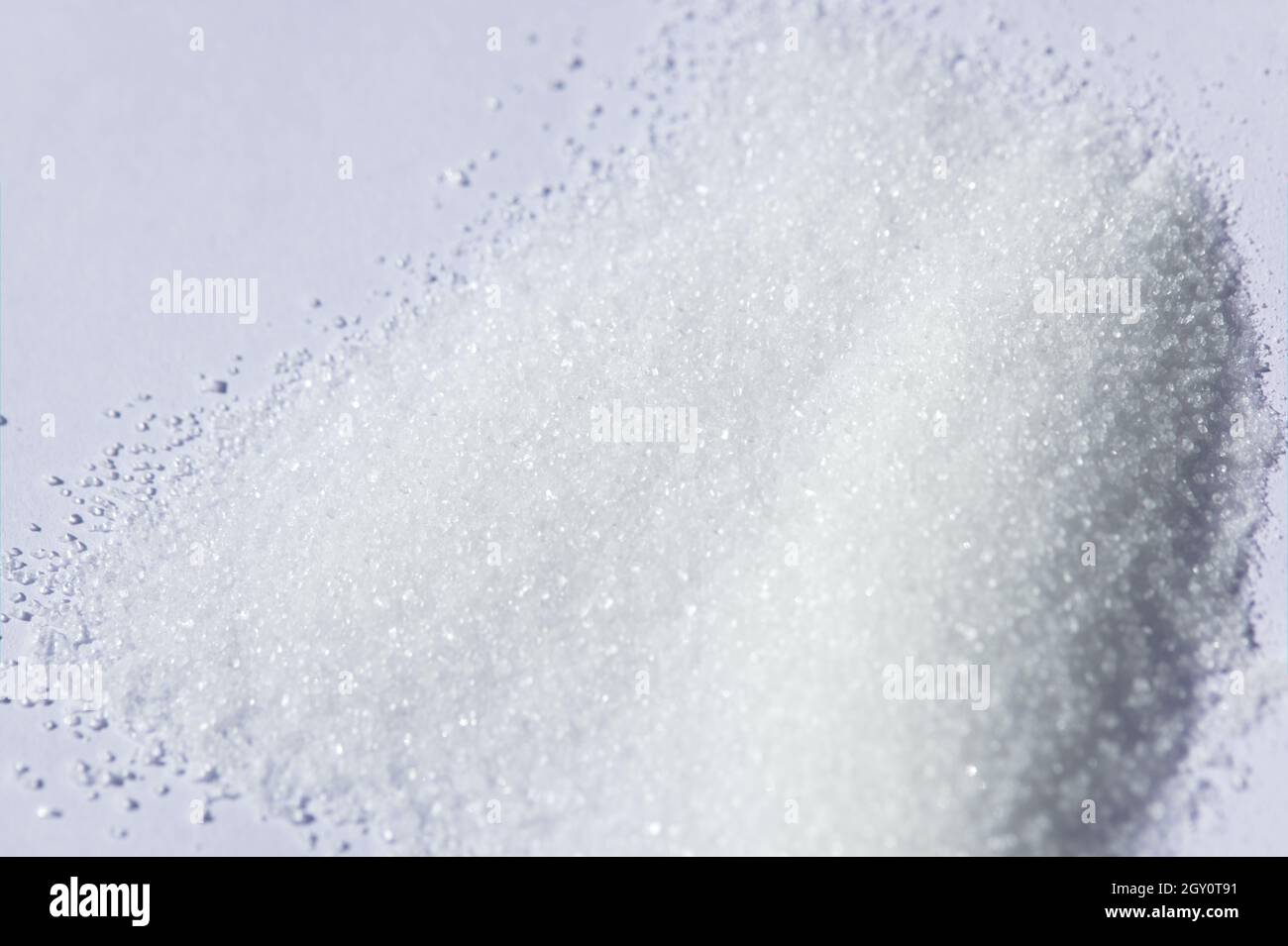 Sugar granules on a white background Stock Photo