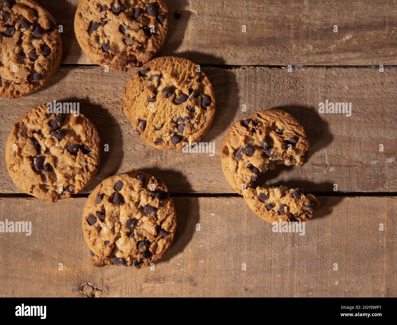 top view of handmade chocolate chip cookies on antique dark wood background Stock Photo