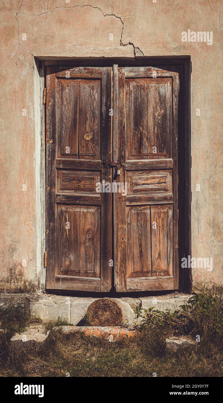 Old shabby faded wooden doors in an abandoned house Stock Photo