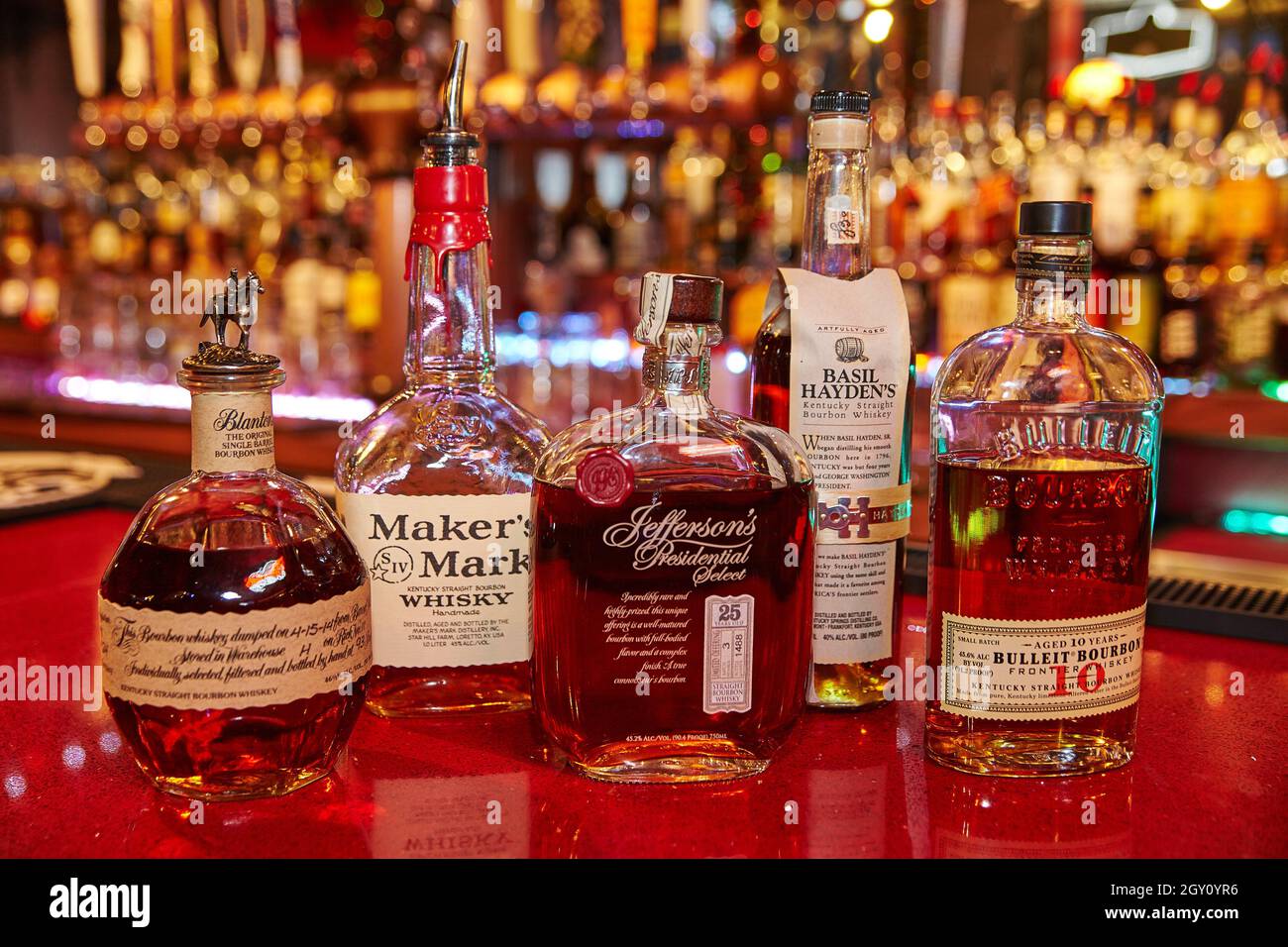 Selection of artisanal whiskies and bourbons with a full bar in the background Stock Photo
